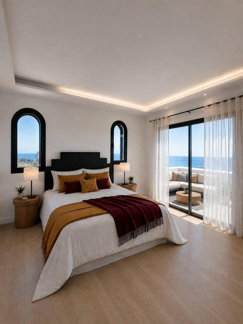 Modern bedroom with a large bed, sea view through arched windows, and a balcony with outdoor seating.