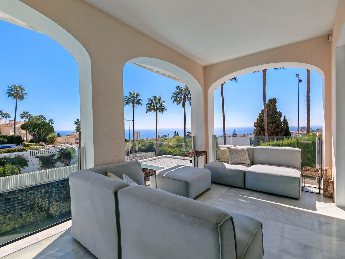 Spacious modern lounge area with comfortable sofas and a stunning panoramic sea view from the terrace.