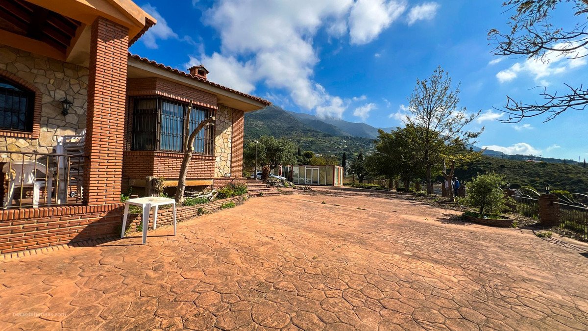 Two-story house with mountain view, brick exterior, patio, and garden.
