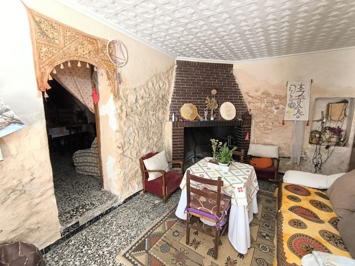 Bohemian living room with a fireplace, a dining table set for two, and unique decorative elements.