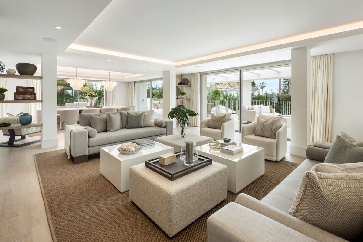 Moderne luxe woonkamer met neutrale kleuren en veel natuurlijk licht.