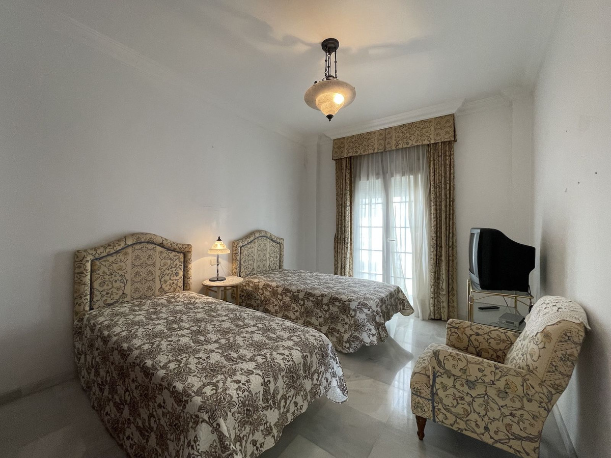 Slaapkamer met twee bedden en een tv.