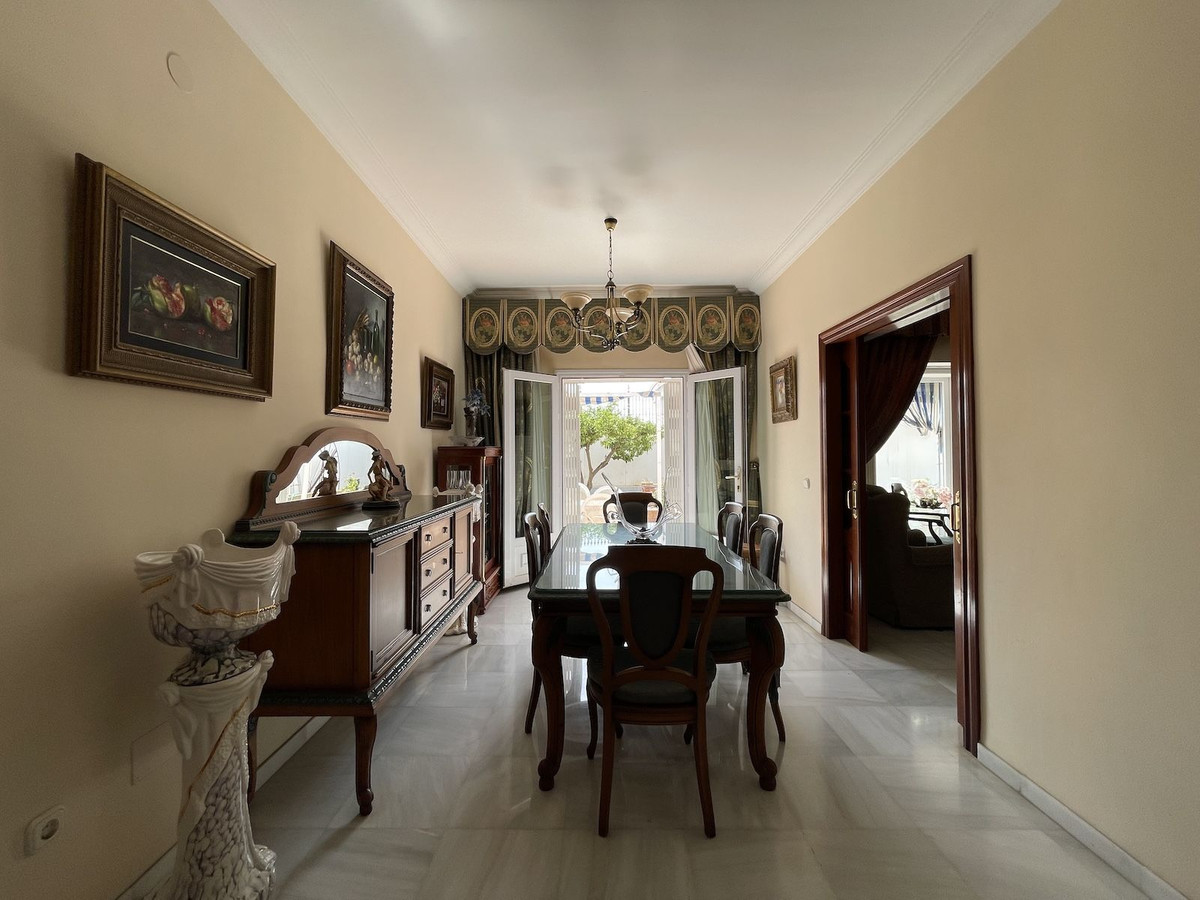 Elegante eetkamer interieur met antieke meubels en openslaande deuren naar de tuin.