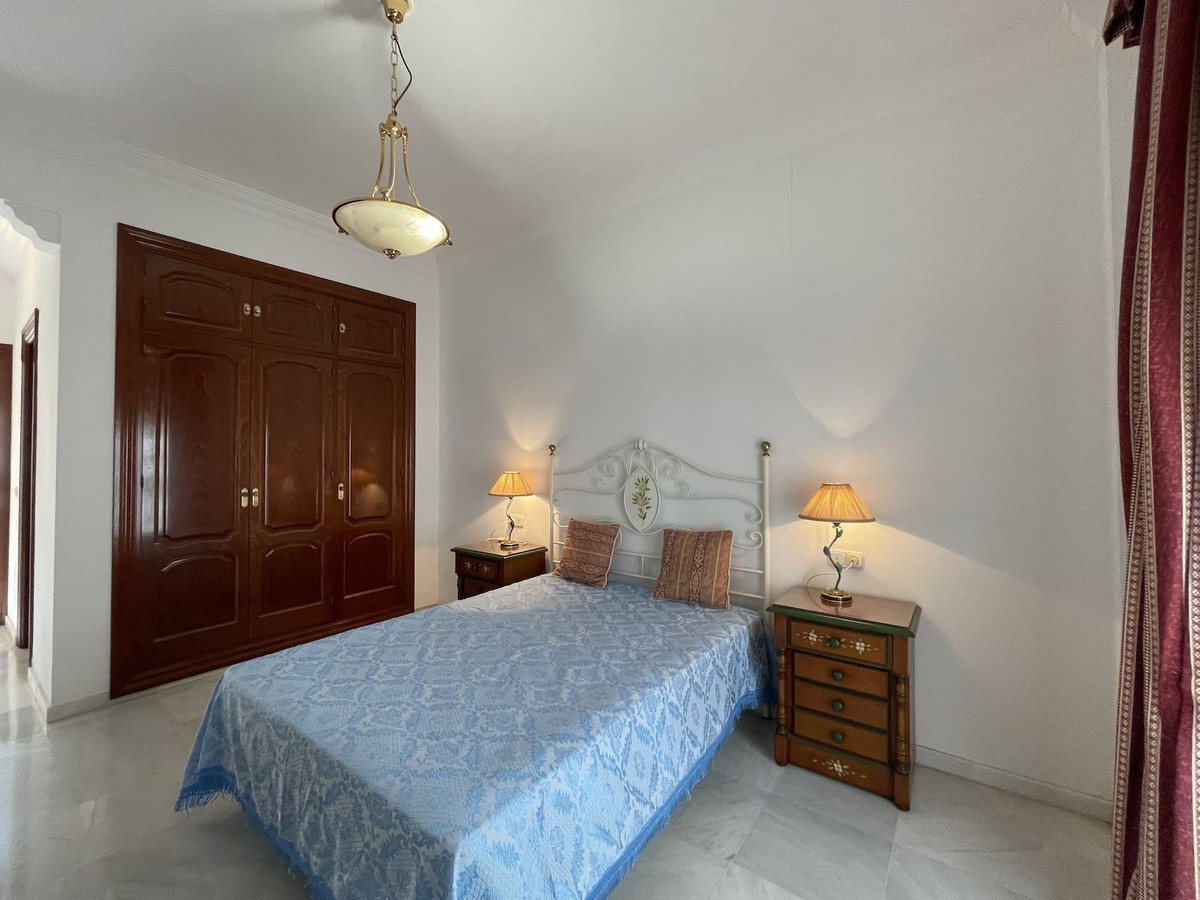 Slaapkamer met blauw sprei, nachtkastjes en kledingkast