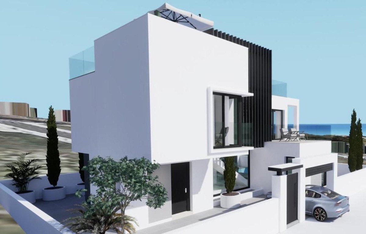 Modern white villa with glass balconies, outdoor seating on a terrace, and a distant sea view.
