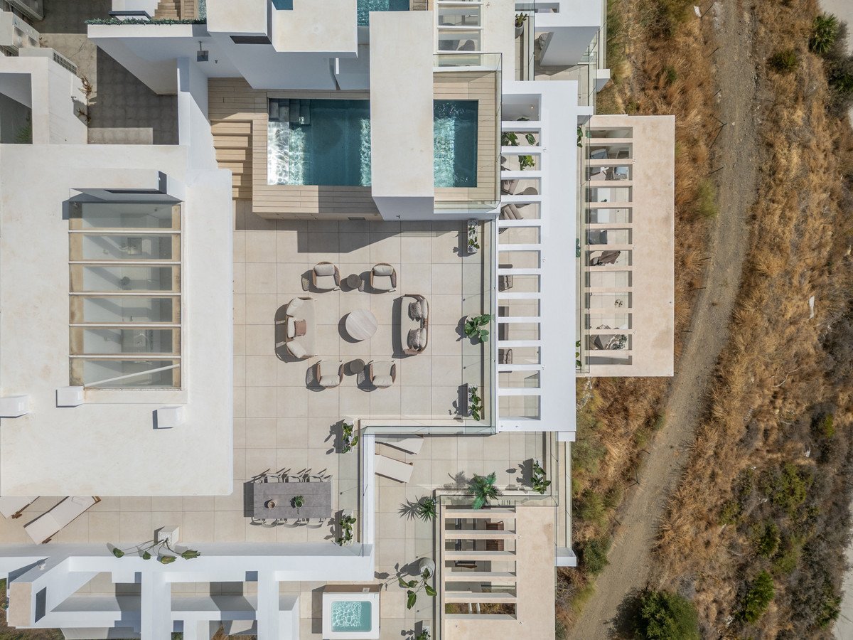 Aerial view of a modern rooftop terrace with two pools, outdoor dining, and lounge seating area.