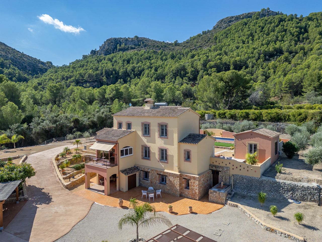 Luxe villa met zwembad aan berghelling, omgeven door groen.