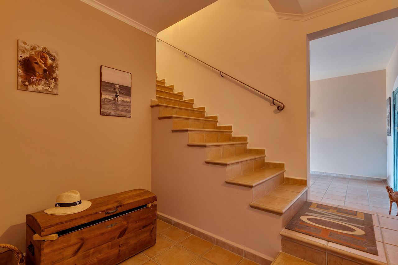 Entree met trap, schatkist en decoratieve elementen.