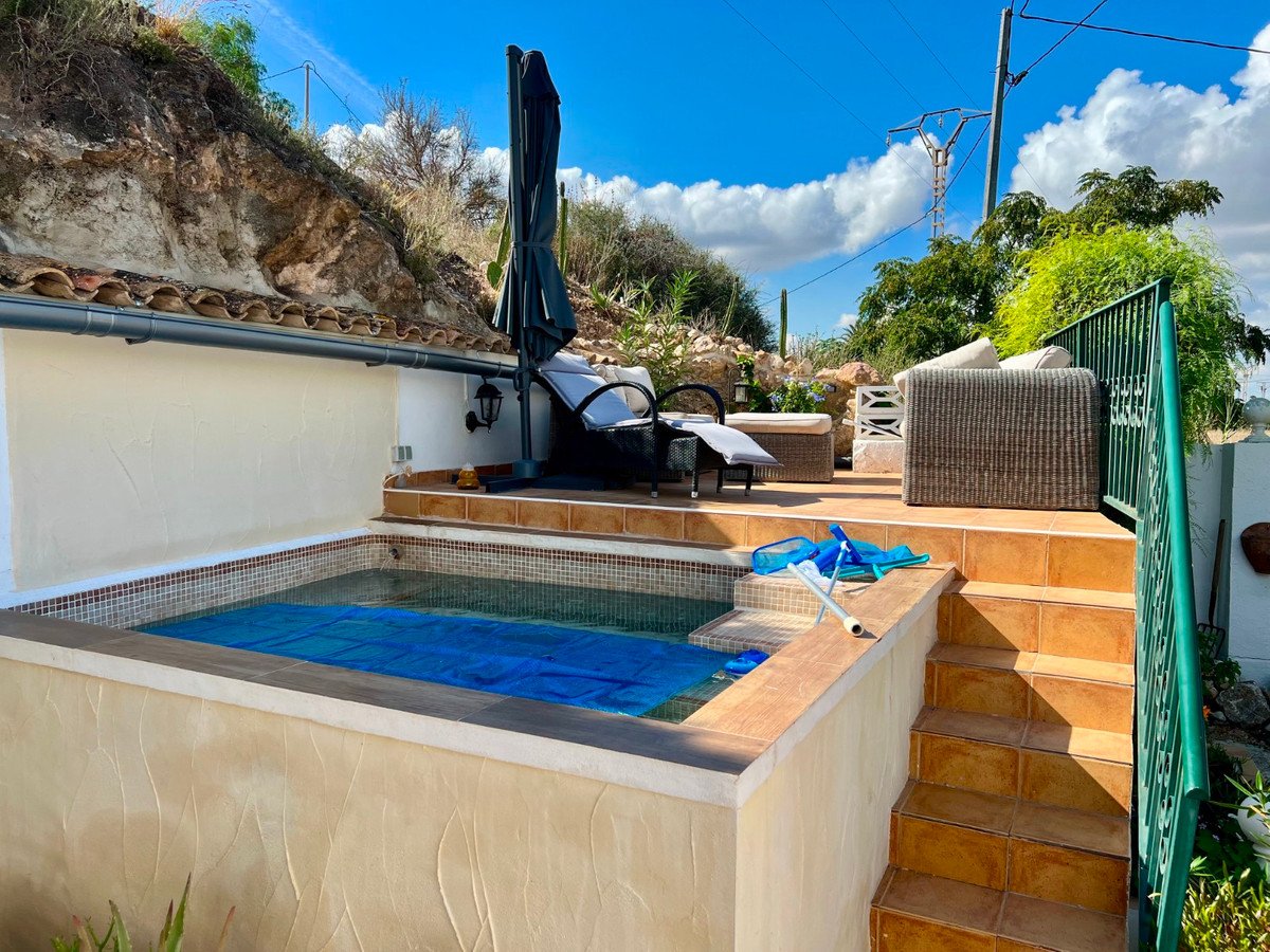Outdoor patio with a small plunge pool, lounge chairs, and seating area