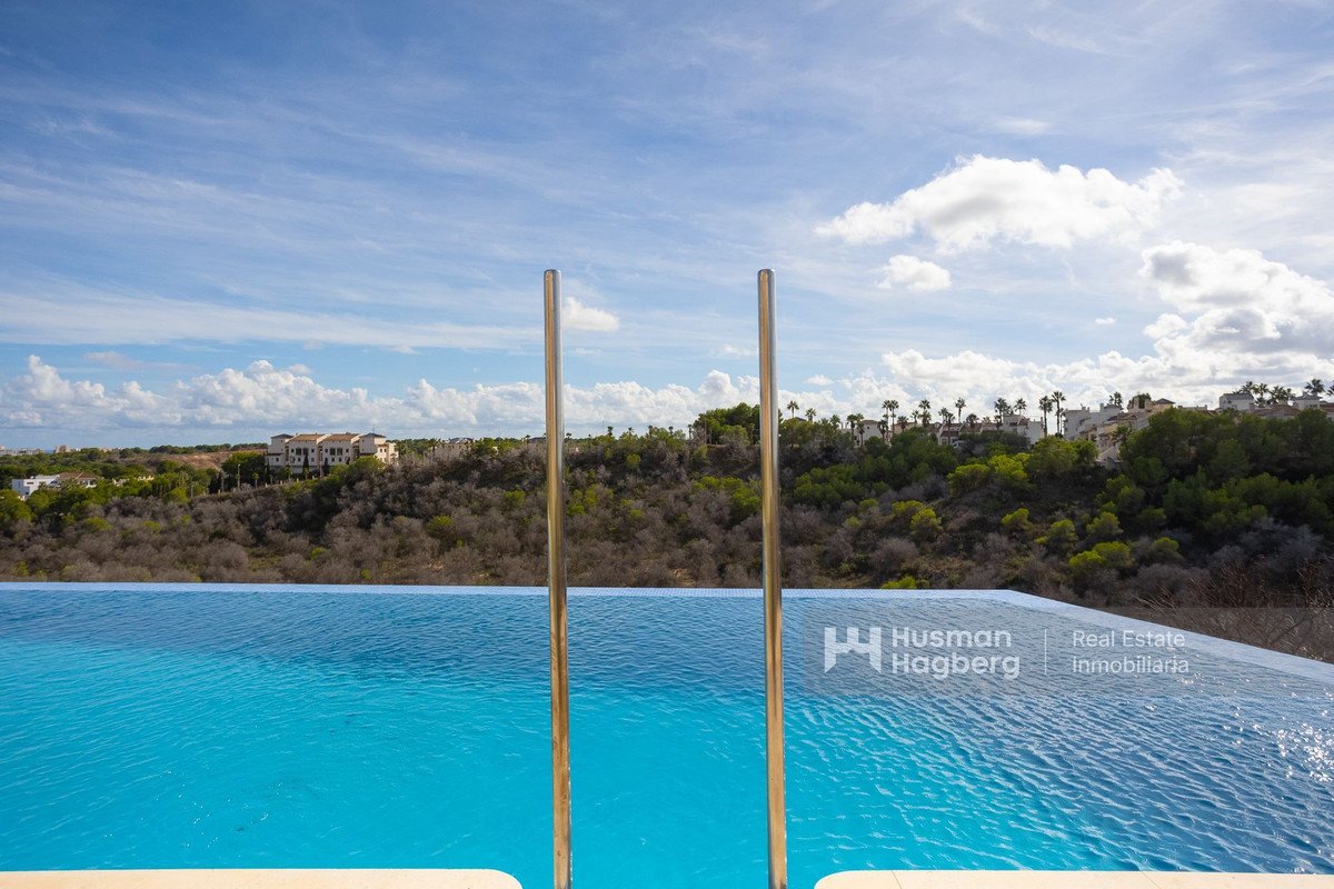 Infinity pool with hillside view and clear blue water