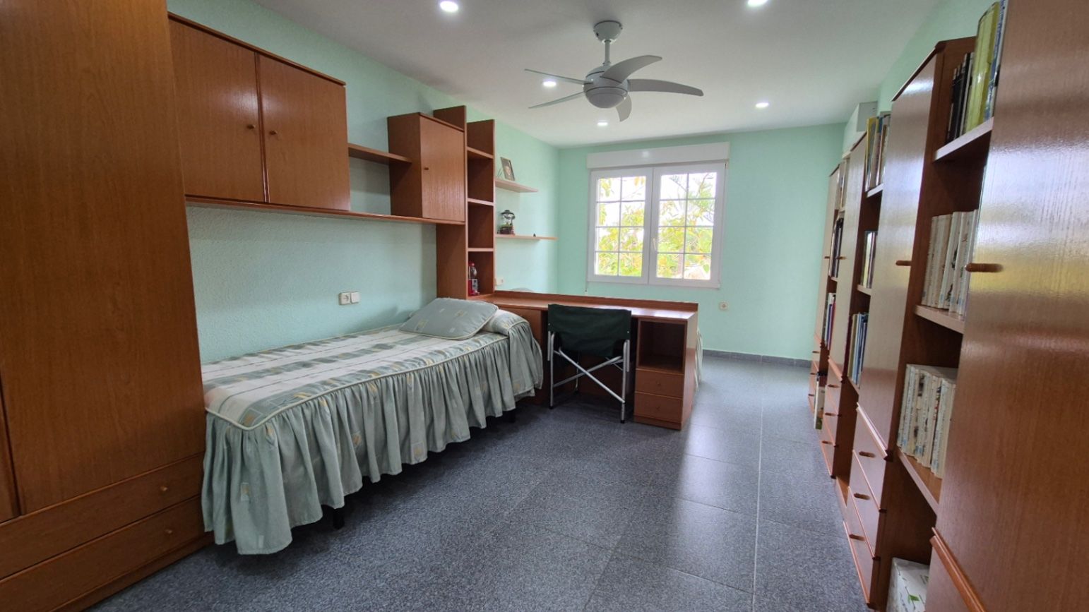 Slaapkamer met bed, bureau en boekenkast