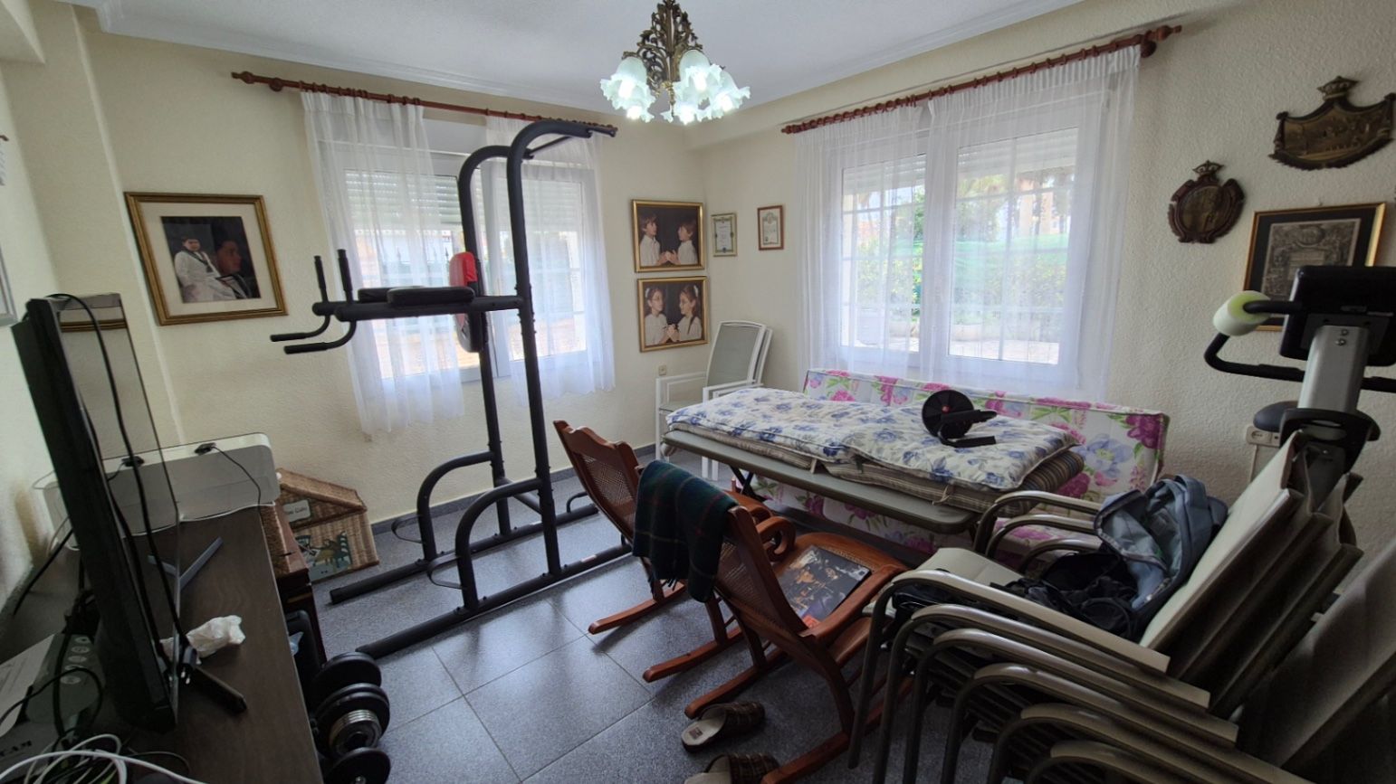 Eclectische kamer met diverse meubels en fitnessapparatuur.