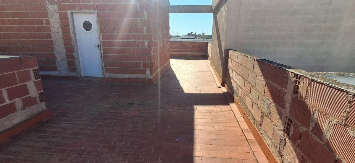 Rooftop terrace with brick walls and a white door