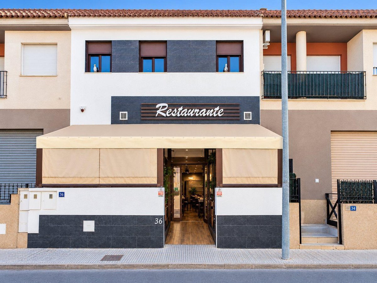 Exterior of a restaurant with a covered entrance and street view