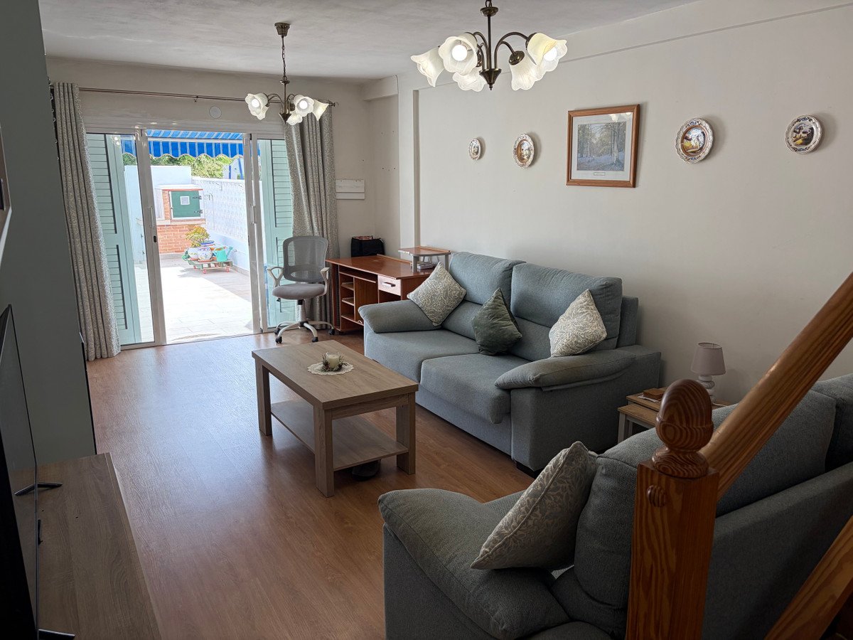 Spacious living room with a grey sectional sofa, coffee table, and patio doors leading to an outdoor area.