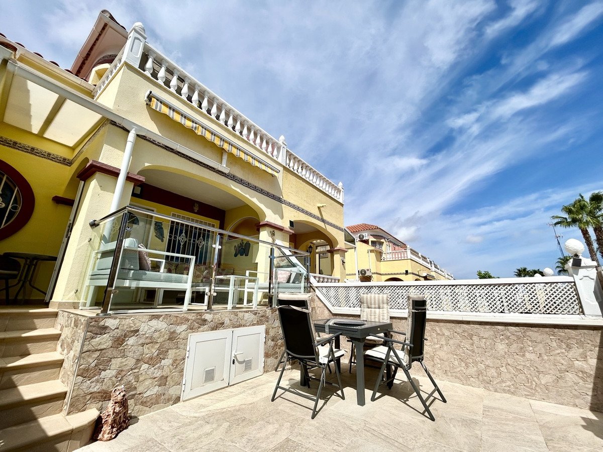 Sunny terrace with outdoor dining table and chairs, and a balcony with seating area overlooking the property.
