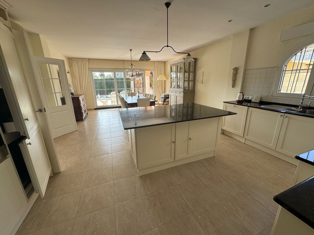 Spacious open-plan kitchen with living and dining area, large windows, and natural light