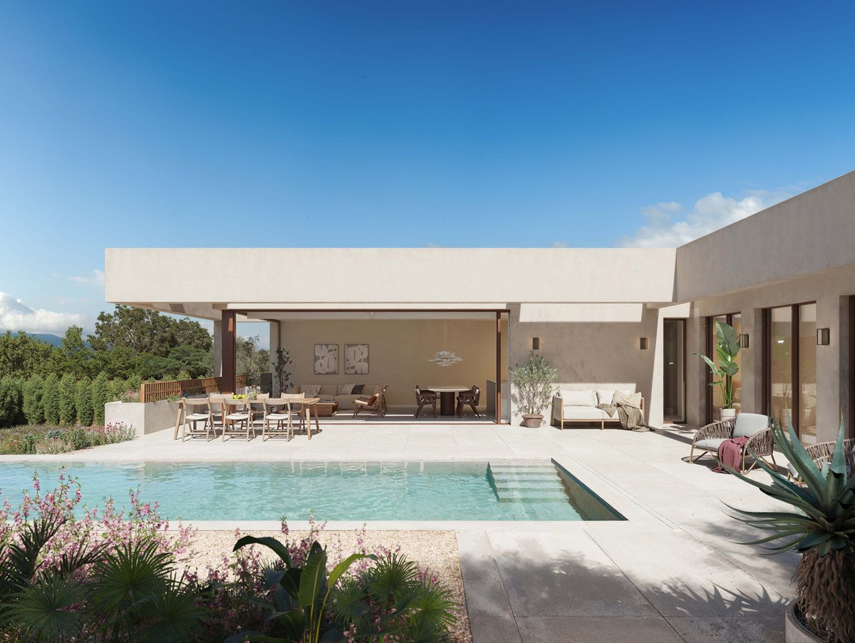 Modern villa courtyard with a swimming pool, outdoor dining, and lounge area with lush greenery and blue sky.