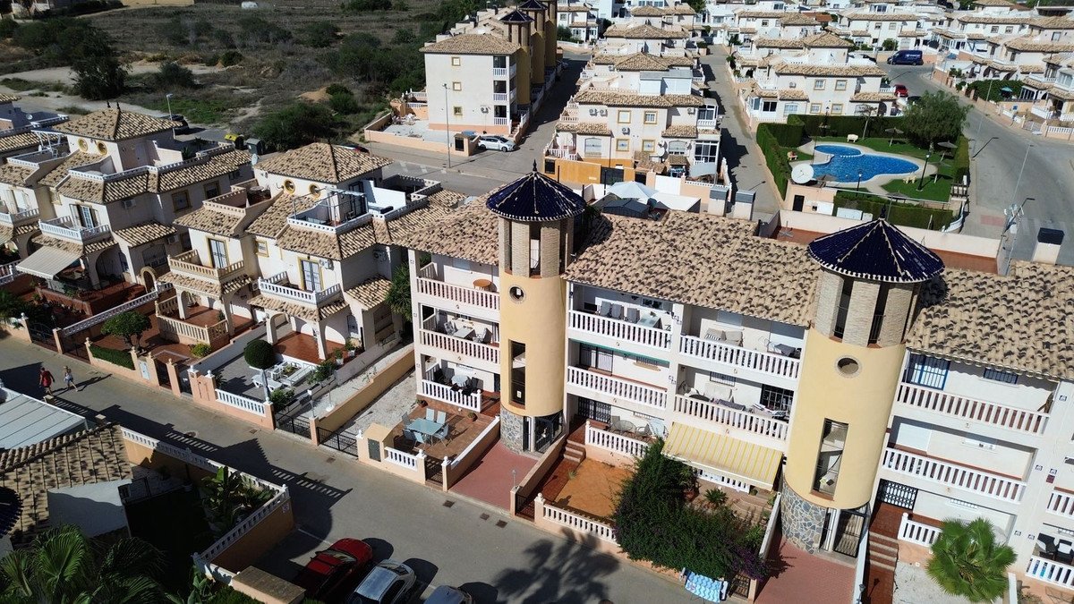 Aerial view of a townhouse complex with multiple units, balconies, and a communal swimming pool area.
