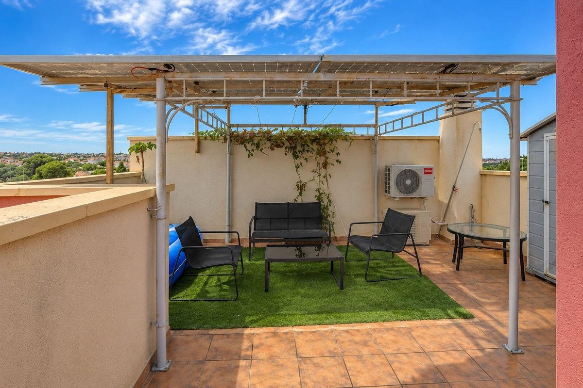 Rooftop patio with solar shade, seating, and city view