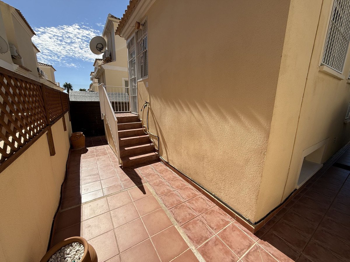 Terraced outdoor area with steps leading up to a building entrance, under a bright sunny sky.