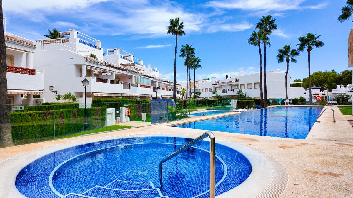 Swimming pool and jacuzzi in a sunny apartment complex with palm trees