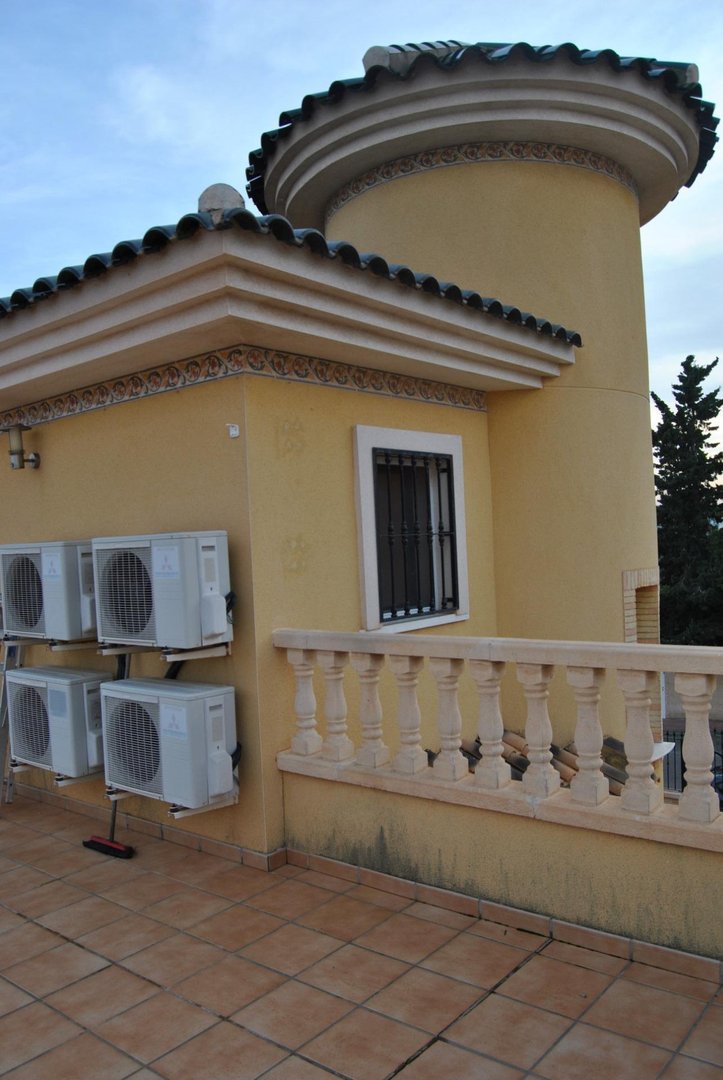 Outdoor terrace with air conditioning units and a decorative tower structure