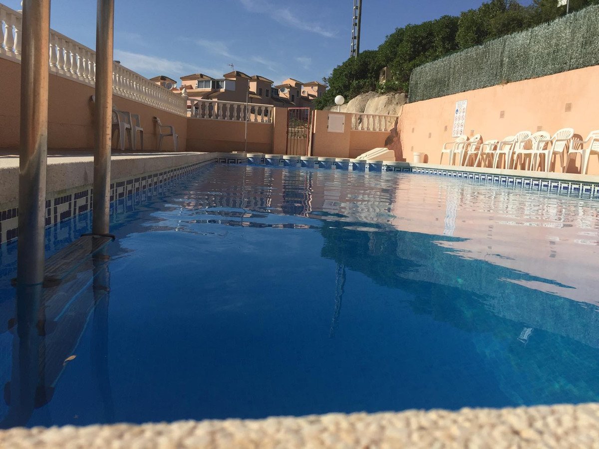 Swimming pool in a residential complex with clear blue water and surrounding buildings