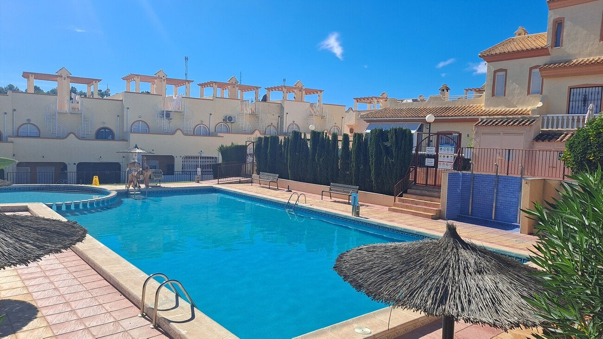 Resort swimming pool with sun loungers and Mediterranean-style buildings
