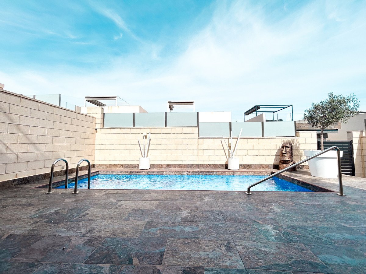 A private swimming pool on a terrace with a clear blue sky, featuring modern fencing and decorative elements.