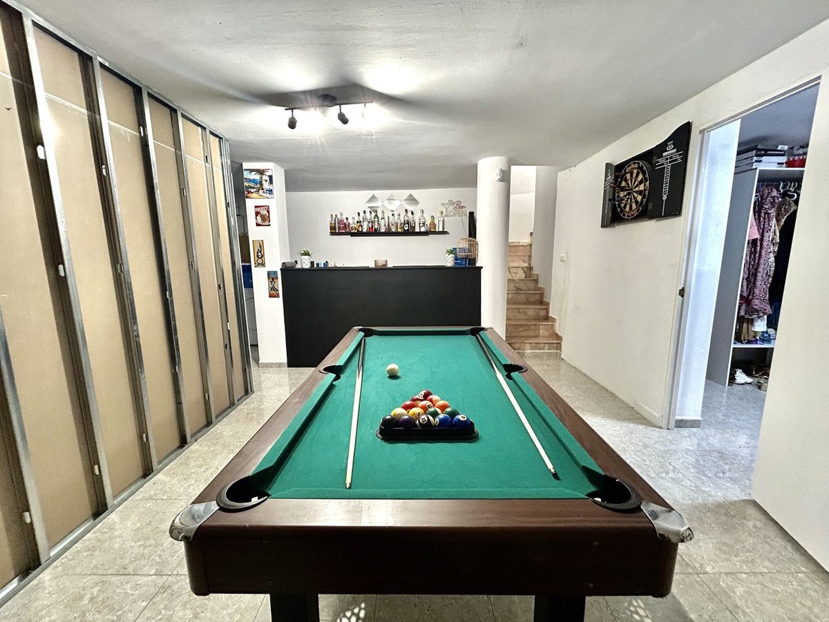 Game room with pool table, bar area, and dartboard in background