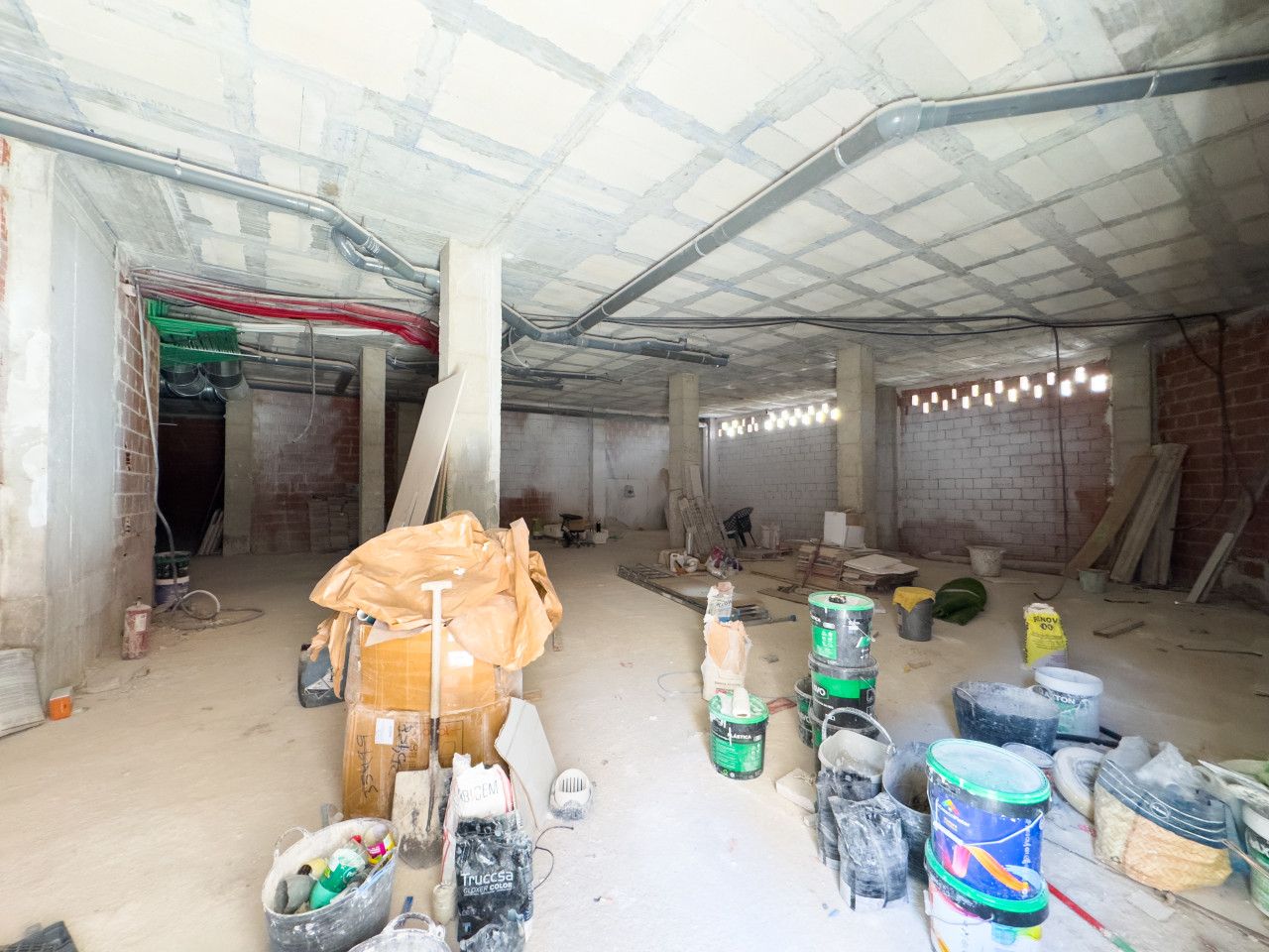 Interieur van een bouwplaats met onafgewerkte constructie en materialen.