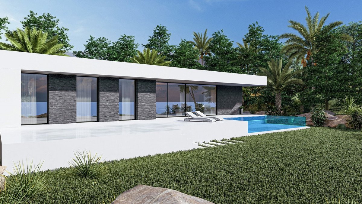 Modern villa with a swimming pool and lounge chairs, overlooking the sea and surrounded by lush tropical greenery.