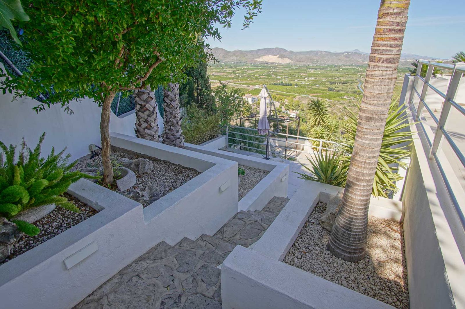 Aangelegde tuin met stenen trap en uitzicht op de bergen.