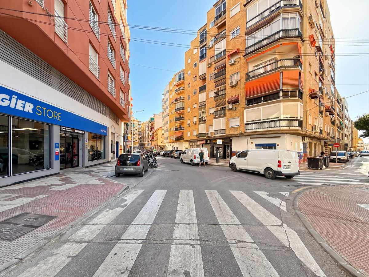 Stadsbeeld in Spanje met gebouwen, auto's en voetgangersoversteekplaats.