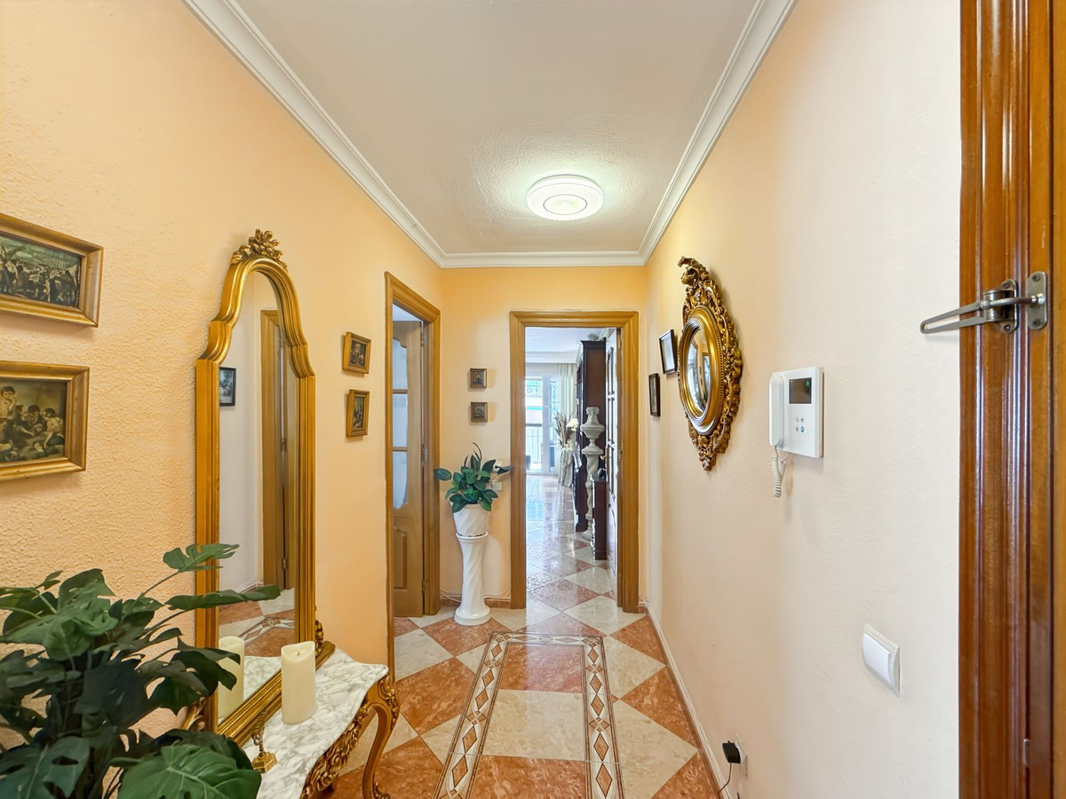 Elegante hal met gouden spiegels en betegelde vloer.