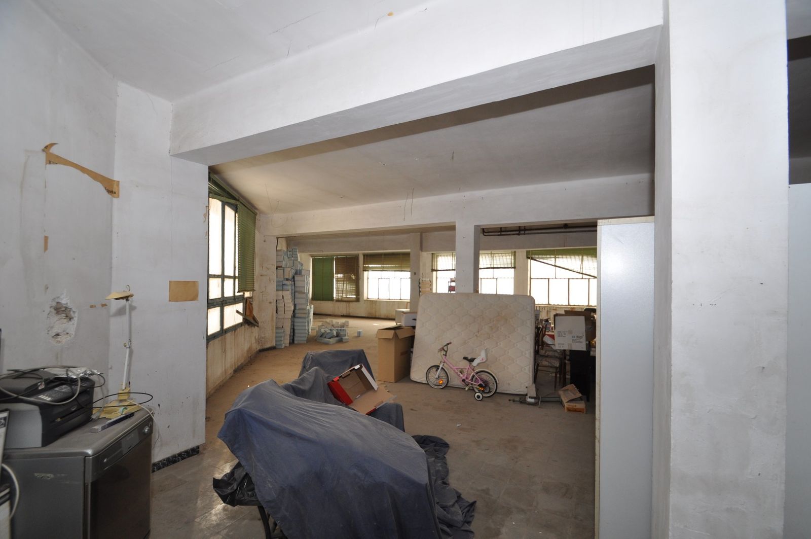 Grote kamer met renovatiepotentieel, rommelig, wachtend op herstel