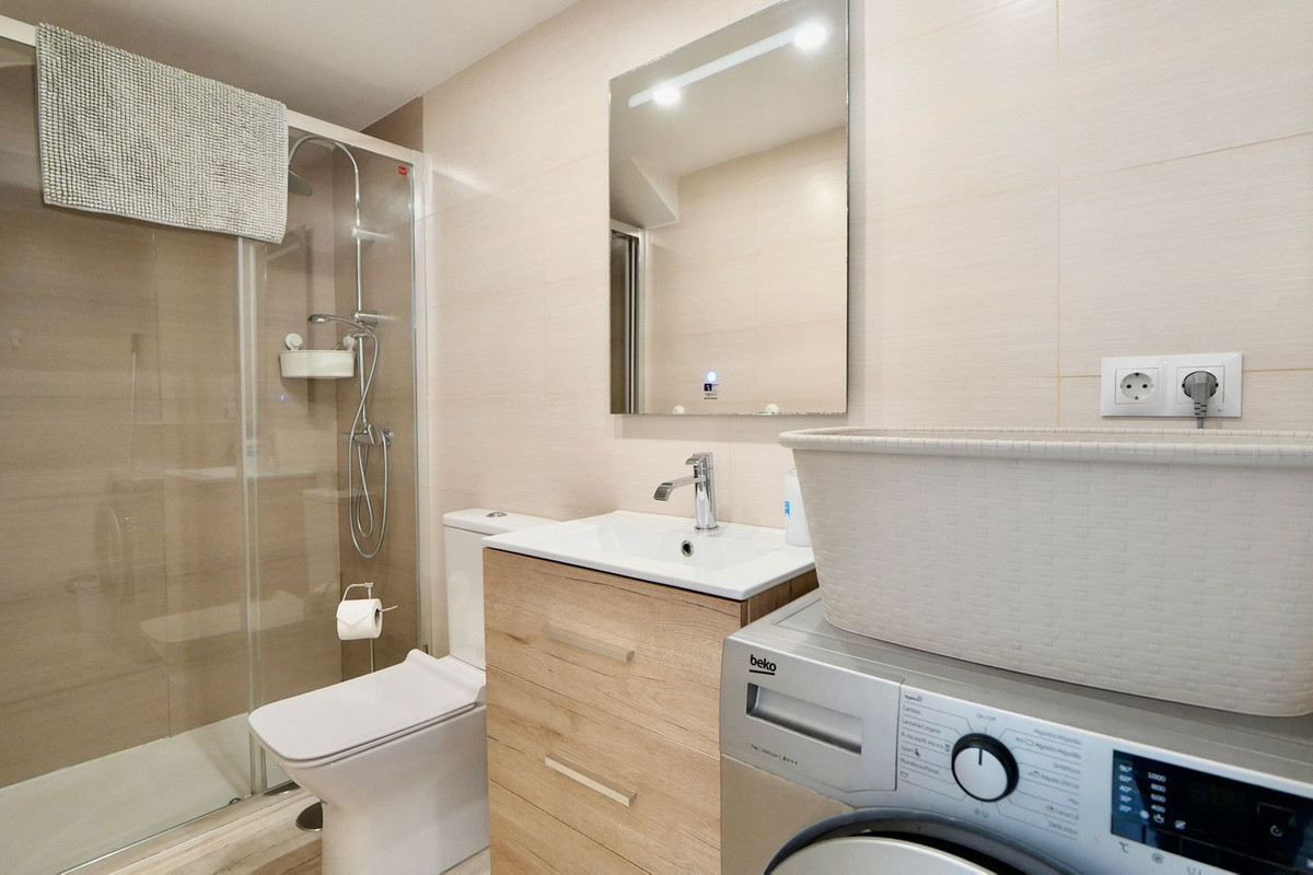 Moderne badkamer met douchecabine, wastafel en wasmachine