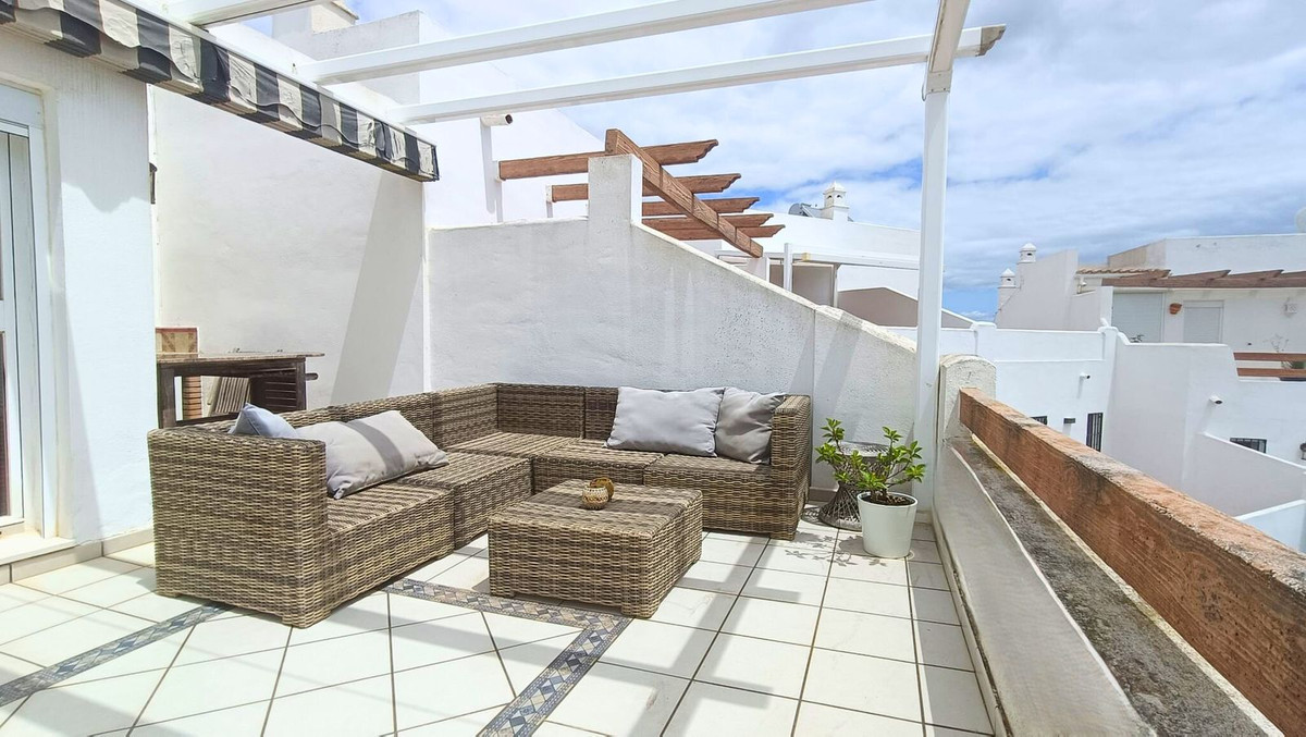 Buiten patio meubilair op een balkon met witte tegels.