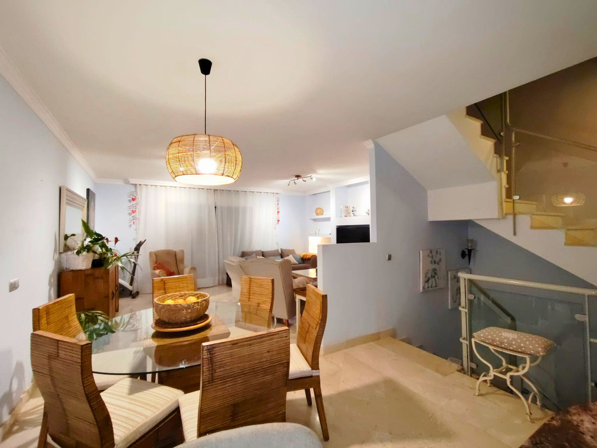 Open eet- en woonkamer met trap en natuurlijke accenten.