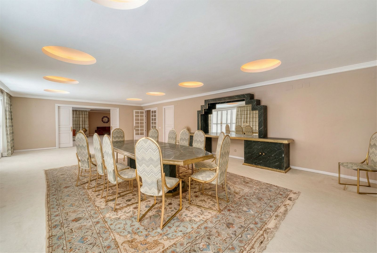 Elegante eetkamer met marmeren tafel en art deco dressoir.