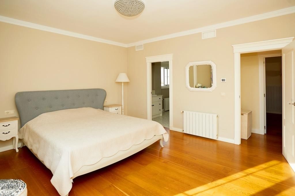 Slaapkamer met houten vloer en beige muren.