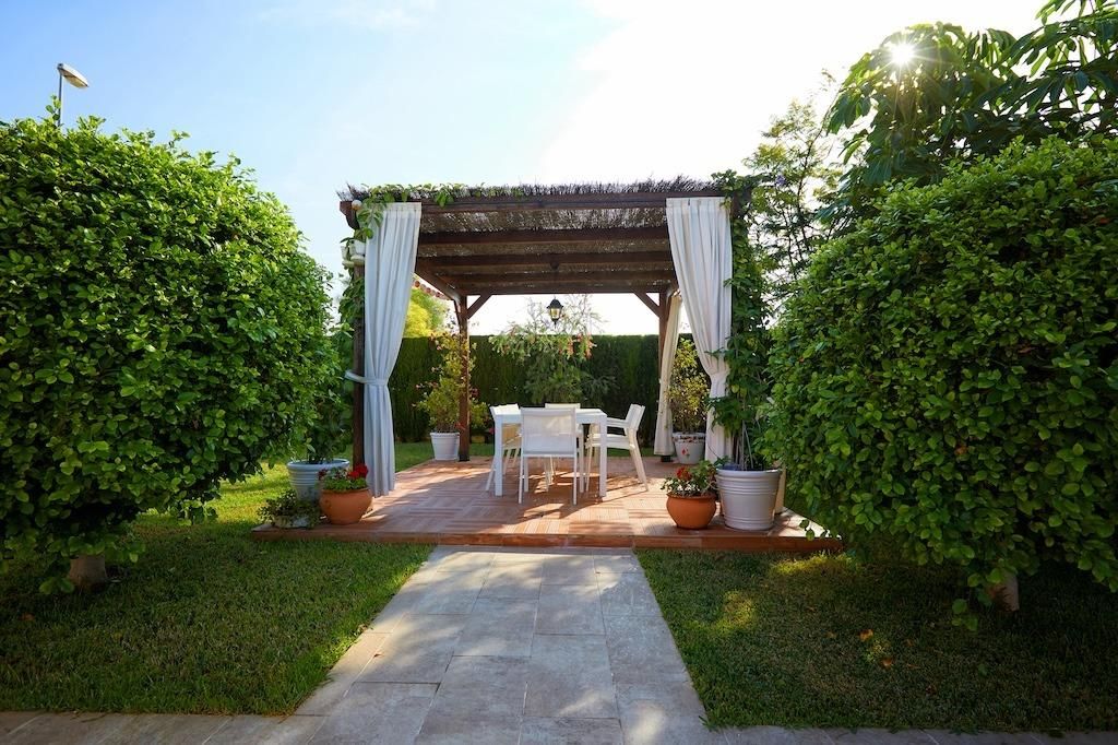 Tuin met pergola en buiteneethoek.