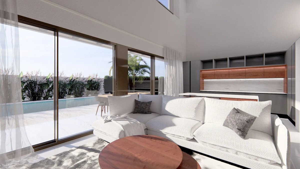 Modern living room with white sofa, wooden table, and large glass doors overlooking a pool and garden.
