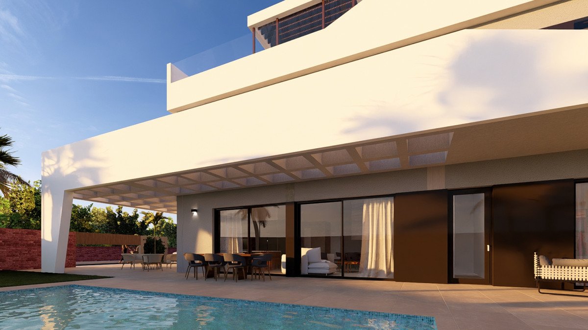 Modern villa with pool, covered patio, large glass doors, and outdoor dining area under a clear blue sky.