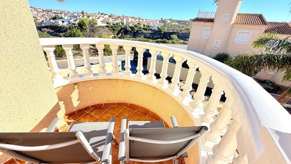 Balcony with chairs overlooking town and sea views