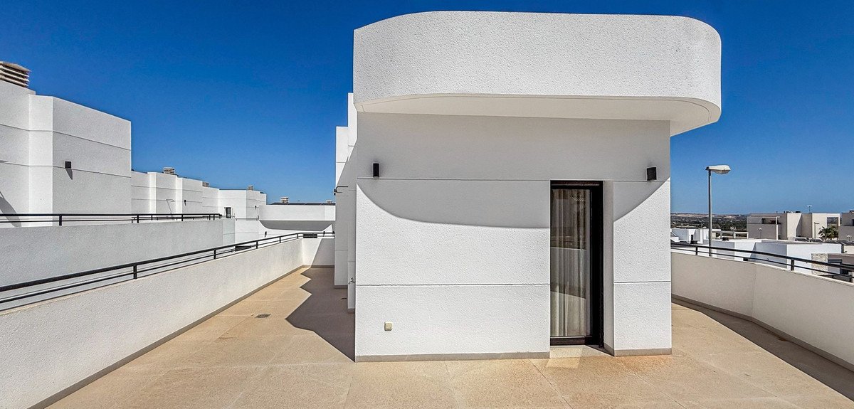 Modern white rooftop terrace with curved building and clear blue sky view