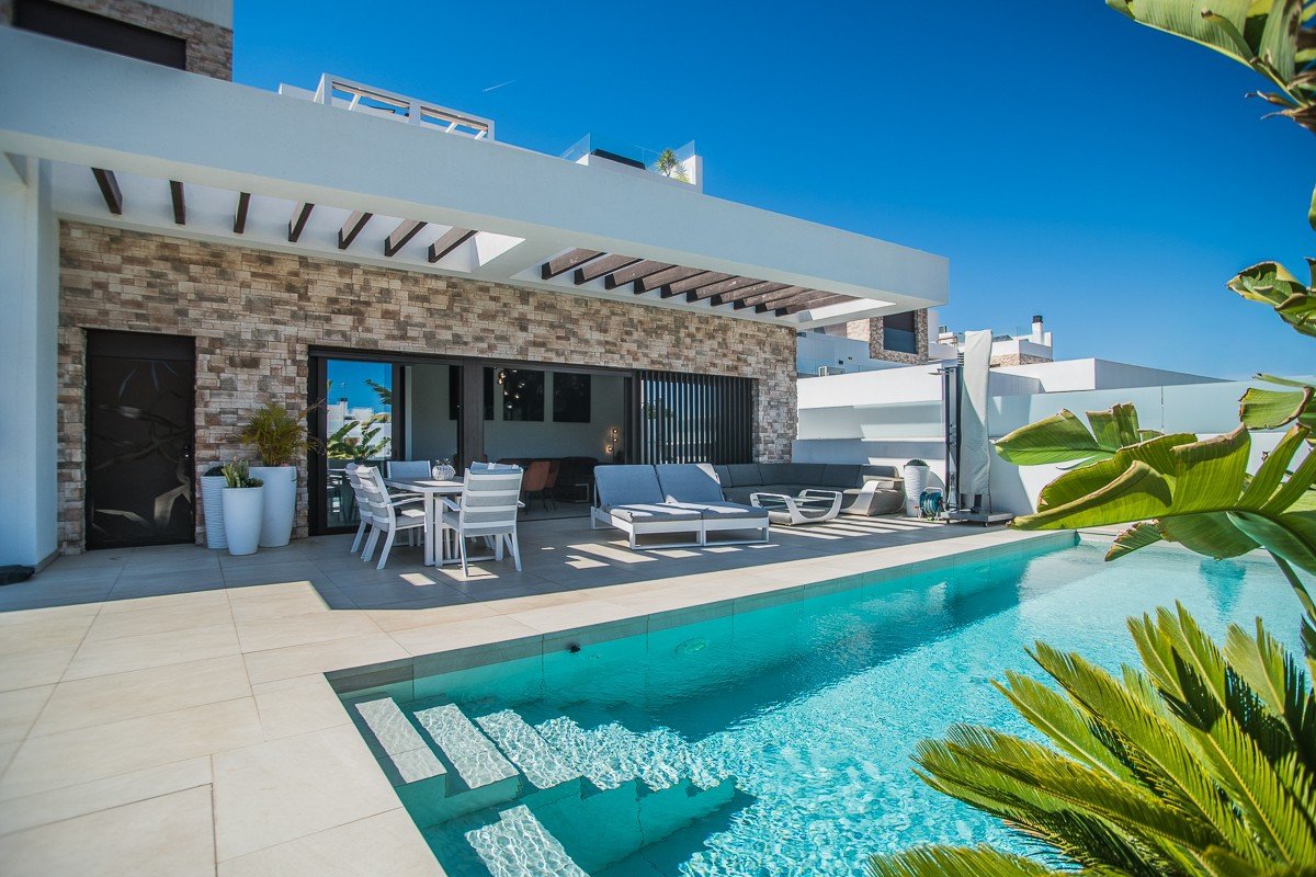 Modern patio with swimming pool, outdoor dining area, and lounge seating.