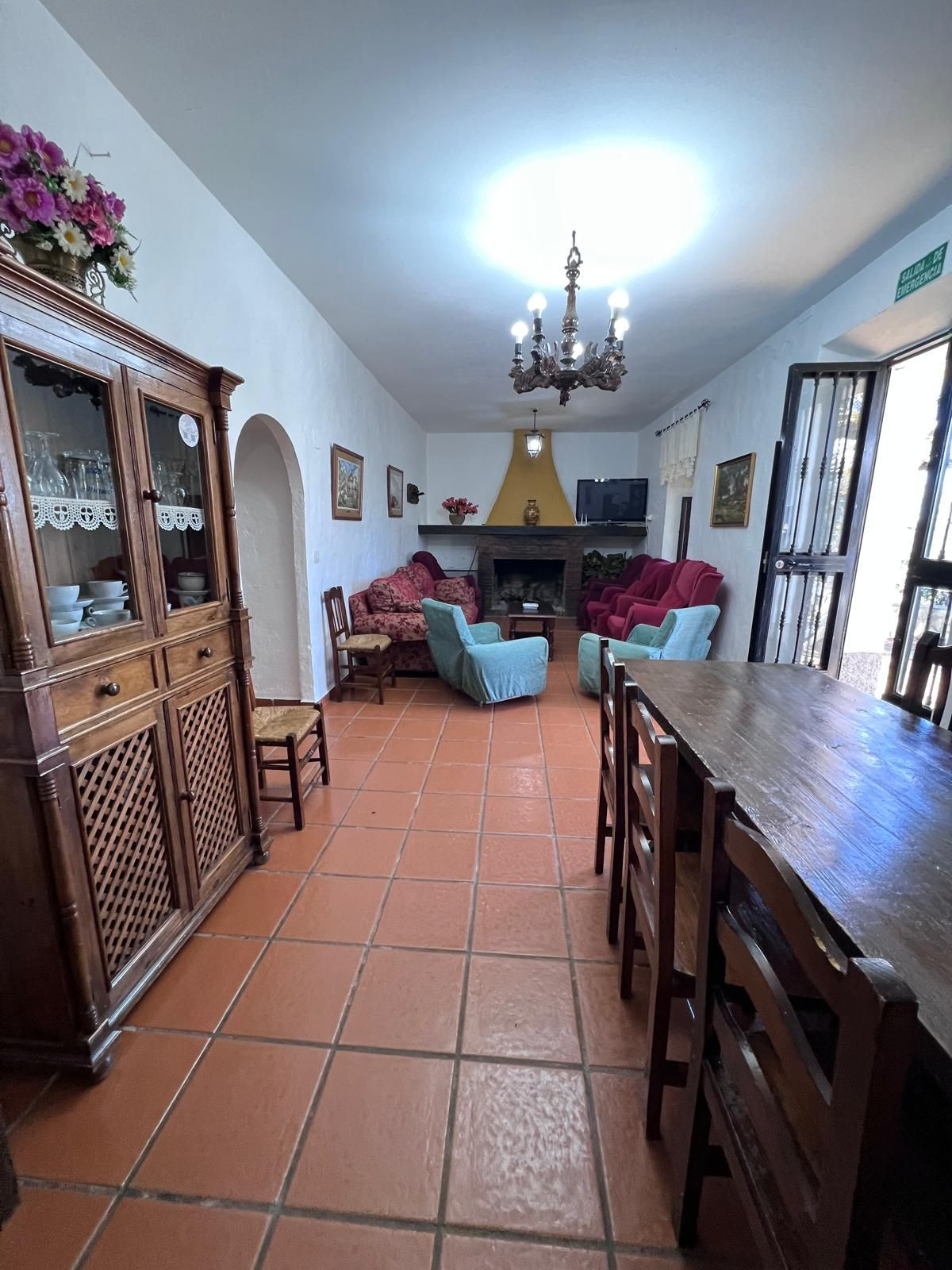 Rustieke eet- en woonkamer met terracotta vloer en houten meubilair.