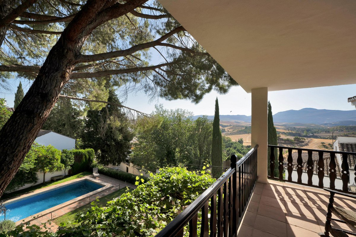 Balcony with view of pool, garden, and distant mountains